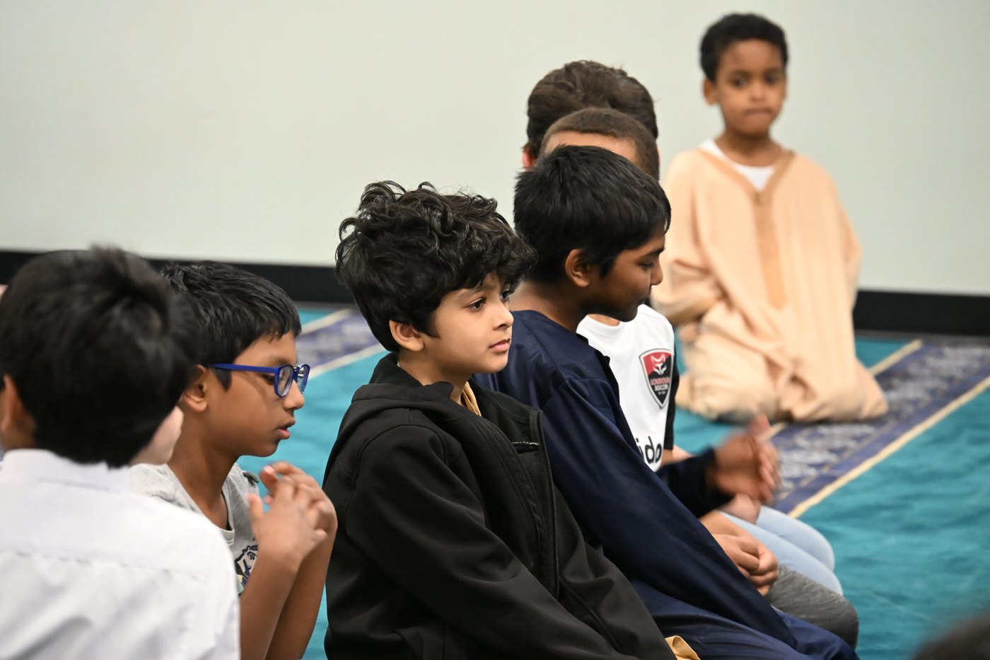 Oceans Academy students listening together in the prayer hall